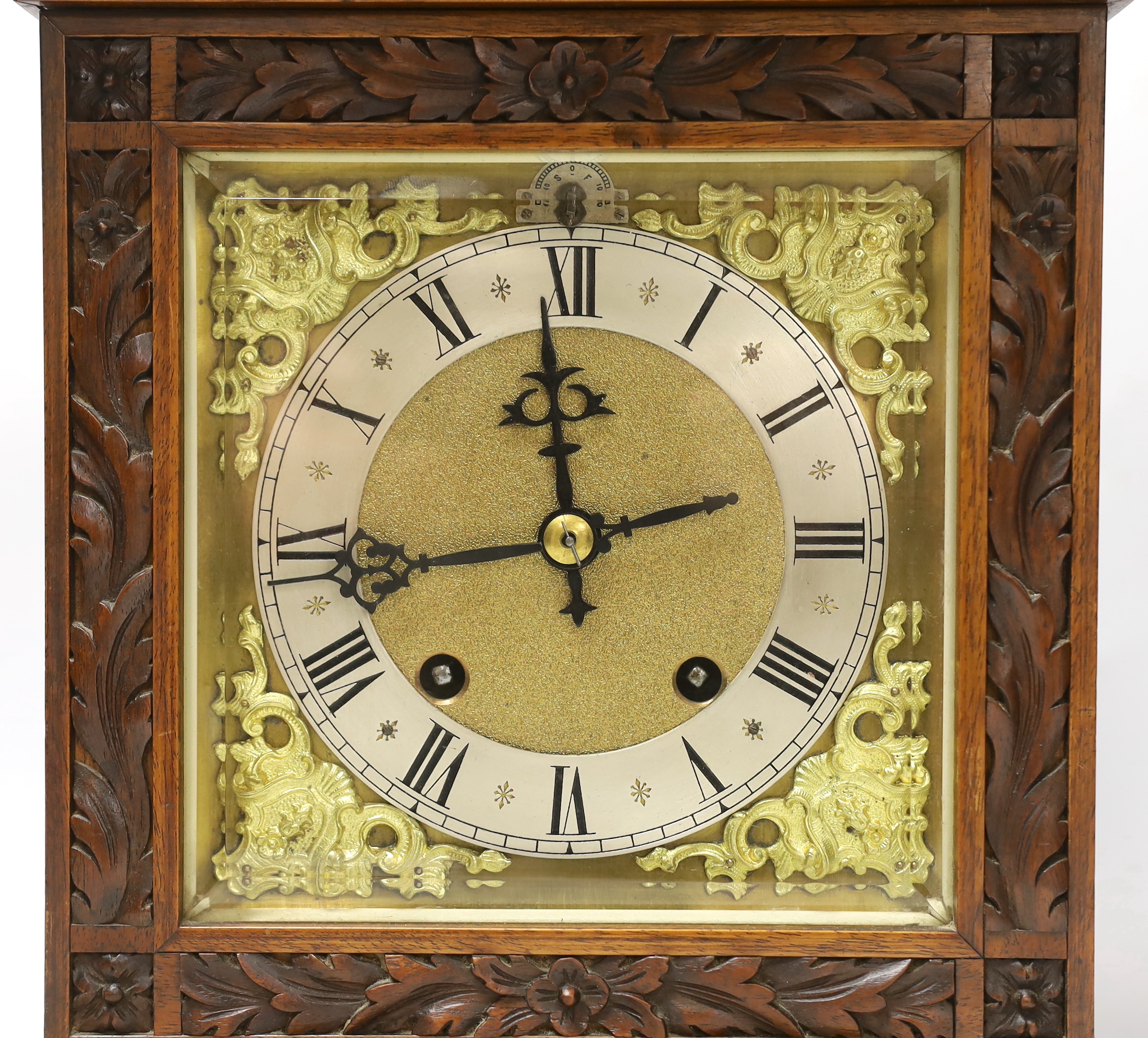 A carved walnut mantel clock with German movement, 36cm